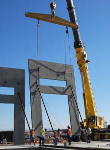 a telescoping boom crane lifting a large piece of precast concrete heavy equipment training