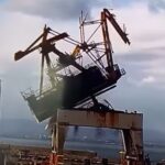 a screenshot of an antique crane that fell over while being demolished
